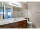 Bright bathroom featuring a single sink vanity with wooden cabinets and a large mirror at 3125 Cristobal Way, Las Vegas, NV 89117