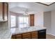 Bright kitchen features tile countertops, white cabinetry, double sinks, and sliding doors to backyard pool at 3125 Cristobal Way, Las Vegas, NV 89117