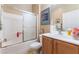 Well-lit bathroom featuring a shower-tub combination with sliding glass door and single sink vanity at 3603 Herring Gull Ln, North Las Vegas, NV 89084