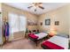 Cozy bedroom with neutral walls, ceiling fan, window with curtains, and two beds with blankets at 3603 Herring Gull Ln, North Las Vegas, NV 89084