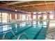 Large indoor pool with multiple lanes, accessible by stairs and exit to a patio at 3603 Herring Gull Ln, North Las Vegas, NV 89084