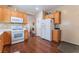 Spacious kitchen featuring wood floors, white appliances, and plenty of cabinet storage at 3603 Herring Gull Ln, North Las Vegas, NV 89084