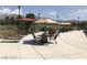 Relaxing pool area with shaded lounge chairs, tables, and beautiful mountain views in the background at 3603 Herring Gull Ln, North Las Vegas, NV 89084