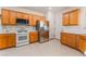 Functional kitchen with oak cabinetry, stainless steel appliances, and neutral flooring; ready for meals at 3608 Herring Gull Ln, North Las Vegas, NV 89084