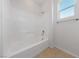 Bathroom featuring a white tub and shower combo with tiled floors and a window at 3718 True Spring Pl, North Las Vegas, NV 89032