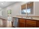 Bright kitchen with stainless steel dishwasher, undermount sink, wood cabinets, and sliding door to backyard at 3718 True Spring Pl, North Las Vegas, NV 89032