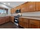 Well-lit kitchen features stainless steel appliances, wood cabinets, and dark hardwood floors at 3718 True Spring Pl, North Las Vegas, NV 89032