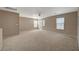 Large, carpeted bonus room with a ceiling fan and bright windows at 4225 Ponce Royal Ave, North Las Vegas, NV 89031
