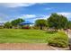 Community park featuring a playground with blue awning, green lawns, trees, and paved walking paths at 4225 Ponce Royal Ave, North Las Vegas, NV 89031