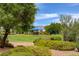Picture of a lush community park featuring a large tree and a blue shaded playground in the background at 4225 Ponce Royal Ave, North Las Vegas, NV 89031