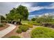 Community park showcasing lush landscaping, green grass, trees, and a blue shaded playground in the distance at 4225 Ponce Royal Ave, North Las Vegas, NV 89031