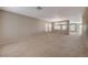 Expansive living room with neutral carpet and walls, complemented by natural light from large windows at 4225 Ponce Royal Ave, North Las Vegas, NV 89031