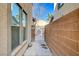 Side yard with a concrete pathway between the house and brick wall leading to a metal gate at 4225 Ponce Royal Ave, North Las Vegas, NV 89031