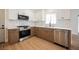 Modern kitchen featuring stainless steel appliances, tile backsplash, and wood look flooring at 427 Wright Way, Henderson, NV 89015