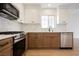 Bright kitchen featuring stainless steel appliances, two-tone cabinetry and backsplash at 427 Wright Way, Henderson, NV 89015