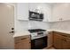 Bright kitchen with stainless steel appliances, white quartz countertops and white and wood cabinetry at 427 Wright Way, Henderson, NV 89015