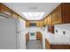 Bright kitchen with wooden cabinets, white appliances, and tiled countertops at 5070 Jeffreys St # 101, Las Vegas, NV 89119