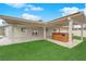 Backyard with jacuzzi tub under a covered patio and manicured artificial turf at 57 Marion Dr, Las Vegas, NV 89110