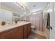 Bathroom with tile floors, wood cabinets, a large mirror, and a shower with a curtain at 6030 Hidden Summit St, North Las Vegas, NV 89031