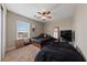 Bedroom with carpet, fan, window, black bedding, and full-length mirror; great natural light at 6030 Hidden Summit St, North Las Vegas, NV 89031