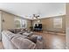 Bright living room featuring a large sectional sofa, a ceiling fan, and lots of natural light from multiple windows at 6030 Hidden Summit St, North Las Vegas, NV 89031