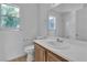 Bright bathroom with a white vanity, toilet, and tiled shower and window at 8112 Broken Spur Ln, Las Vegas, NV 89131