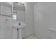 Clean, simple bathroom with a pedestal sink, white fixtures, and tile flooring at 8112 Broken Spur Ln, Las Vegas, NV 89131