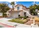 Charming stucco home with a two-car garage and manicured landscaping at 8112 Broken Spur Ln, Las Vegas, NV 89131