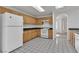Kitchen with wood cabinets, white appliances, and tiled floor at 8112 Broken Spur Ln, Las Vegas, NV 89131