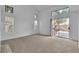 Bright living room with multiple windows, neutral carpet, and access to the backyard patio at 8112 Broken Spur Ln, Las Vegas, NV 89131
