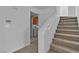 Carpeted staircase with white railing, adjacent to a laundry area and doorway, leading upstairs at 8112 Broken Spur Ln, Las Vegas, NV 89131