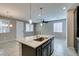 Open dining and living area showing tile floors, neutral paint colors and an island with sink at 8487 Insignia Ave # 105, Las Vegas, NV 89178