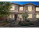Beautiful townhome with landscaped front yard and inviting covered entry featuring decorative stone pillar accents at 8487 Insignia Ave # 105, Las Vegas, NV 89178