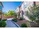 Inviting townhome with landscaped front yard, decorative rock, walkway, and covered entry with stone accents at 8487 Insignia Ave # 105, Las Vegas, NV 89178