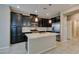 Modern kitchen features dark cabinets, stainless steel appliances, and granite countertops on a large island at 8487 Insignia Ave # 105, Las Vegas, NV 89178