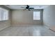 Bright living room featuring large windows and tile flooring, complemented by a ceiling fan for added comfort at 8487 Insignia Ave # 105, Las Vegas, NV 89178