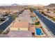 A high-angle aerial shot displays swimming pools in a neighborhood surrounded by scenic mountains at 996 Cetona Ct, Henderson, NV 89011