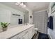 Bright bathroom with a quartz countertop, white cabinetry, and a framed mirror at 996 Cetona Ct, Henderson, NV 89011