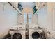 Well-organized laundry room with two front-load Samsung washers and white shutters at 996 Cetona Ct, Henderson, NV 89011