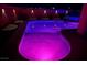 Backyard with a pool lit up in purple at night and accented by landscape lighting at 996 Cetona Ct, Henderson, NV 89011