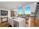 A modern kitchen with a quartz countertop island, stainless steel appliances, hardwood flooring, and a dining and living area at 11441 Allerton Park Dr # 212, Las Vegas, NV 89135