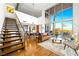 A living area with stairs, a brown leather sofa, hardwood flooring, a view of the city, and access to a patio at 11441 Allerton Park Dr # 212, Las Vegas, NV 89135