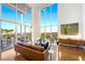 A living area with a brown leather sofa, hardwood flooring, large windows, and an outdoor patio view at 11441 Allerton Park Dr # 212, Las Vegas, NV 89135
