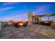 Elegant rooftop patio with fire pit, ample seating, and stunning city views at twilight at 11441 Allerton Park Dr # 212, Las Vegas, NV 89135