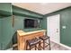 The game room features a custom wood bar with stools and a large screen TV at 1812 Renada Cir, North Las Vegas, NV 89030