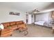 Bedroom with a brown sectional sofa, bed, ceiling fan, and light-colored walls at 1812 Renada Cir, North Las Vegas, NV 89030