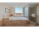 A luxurious bathtub with a view of the city skyline, adjacent to a glass shower at 2000 N Fashion Show Dr # 3307, Las Vegas, NV 89109