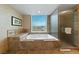 A luxurious bathtub with a view of the city skyline, adjacent to a glass shower at 2000 N Fashion Show Dr # 3307, Las Vegas, NV 89109