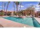 Inviting community pool with lounge chairs, a spa, and lush palm trees at 2120 Ramrod Ave # 1318, Henderson, NV 89014