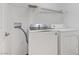 Bright laundry room with modern, white washer and dryer and overhead wire rack at 2120 Ramrod Ave # 1318, Henderson, NV 89014
